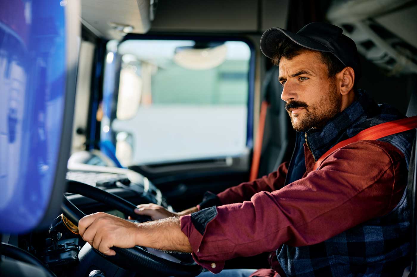 Commercial truck driver behind the wheel preparing to return to work after a DOT SAP evaluation.